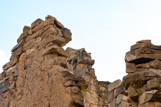 Rovine di antiche mura di pietra contro un cielo nuvoloso