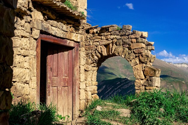 Rovine di una casa nel villaggio abbandonato di Gamsutl con vista sulle montagne