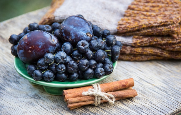 Rowan nero e prugne sulla tavola di legno.