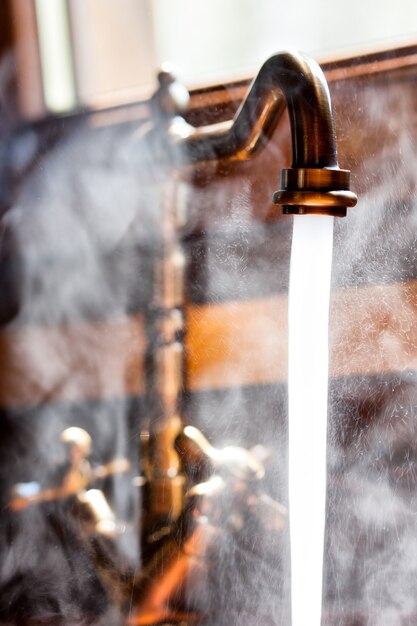 Rubinetto d'epoca funzionante con acqua calda. Vista ravvicinata