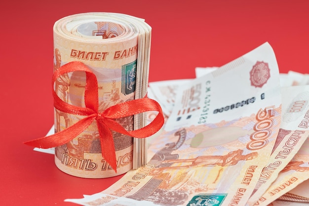 Rubli russi cinquemila banconote pacco di denaro con nastro rosso su sfondo rosso concetto regalo