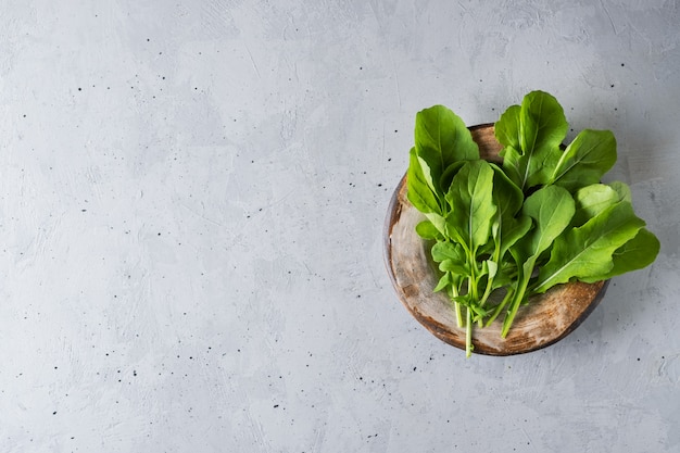 Rucola fresca verde su sfondo grigio