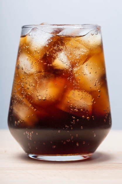 Rum con cola e ghiaccio in una cola di vetro con bevanda estiva ghiacciata