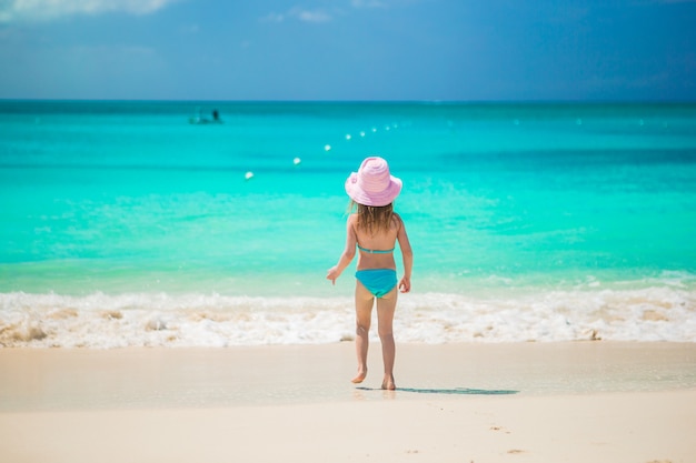 Runing adorabile della bambina in acque basse alla spiaggia esotica