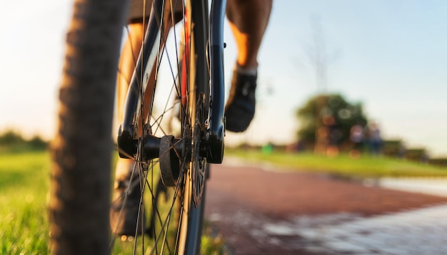 Ruota anteriore della bicicletta da vicino Ciclista in sella a una bicicletta