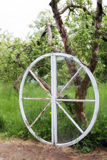 ruota decorativa in legno bianco nell'arredamento estivo del giardino in stile rustico