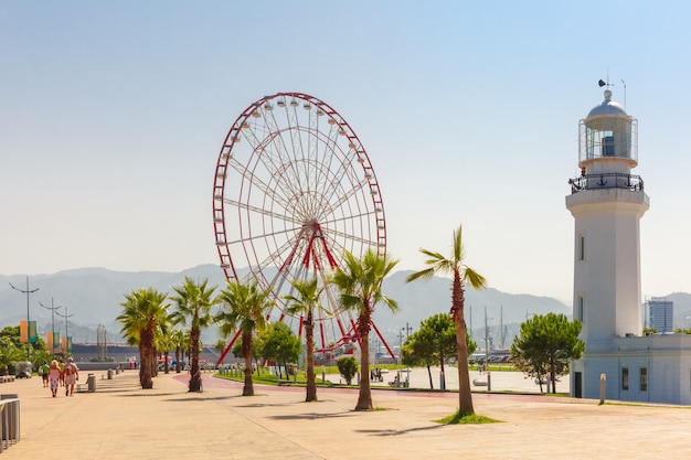 Ruota panoramica e faro di Batumi sulla passeggiata del lungonmare di Batumi nel giorno di estate soleggiato, Adjara, Georgia