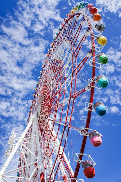 Ruota panoramica gigante variopinta con cielo blu e la nuvola