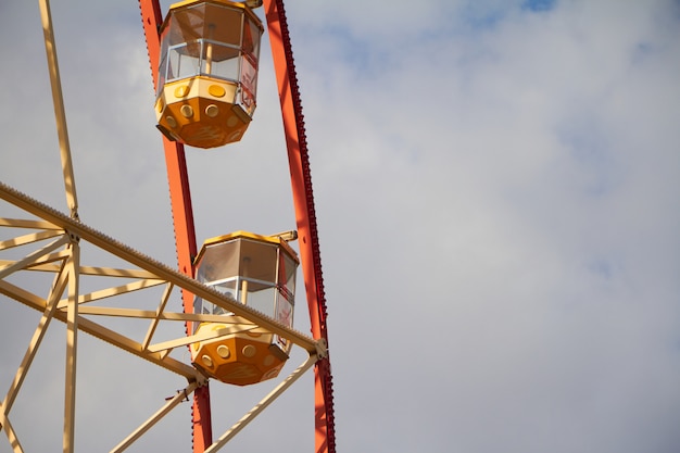 Ruota panoramica moderna del primo piano contro cielo blu e le nuvole bianche, festival di divertimento