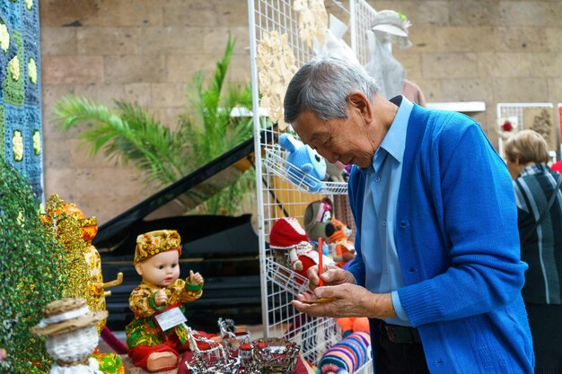 Russia, Gatchina, 14 ottobre 2022 Un anziano asiatico in una mostra artigianale