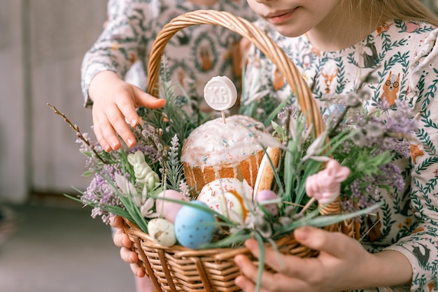 Russia Mosca 04092022 felice vacanza di pasqua nella stagione primaverile famiglia e bambini piccoli sorelle tiene cesto con uova dipinte e dolci pasquali decorazioni per la casa cibo tradizionale