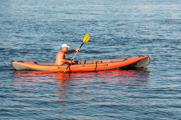 Russia San Pietroburgo giugno 2022 Un uomo con il torso nudo controlla un kayak sul fiume
