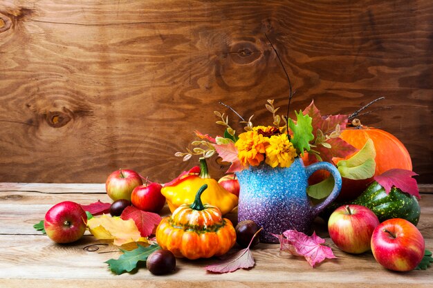 Rustico arrangiamento del Ringraziamento con zucche e fiori di tagetes