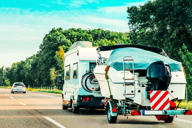 RV Camper Car con barca a motore su strada. Roulotte e camper in viaggio in Svizzera.