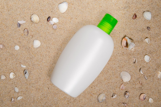 Sabbia di mare con una bottiglia per crema solare o lozione