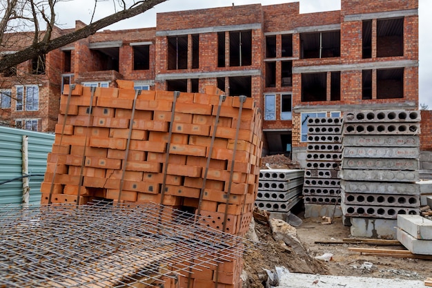 Sabbia e mattoni della carriola della ruota degli strumenti del cantiere alla nuova betoniera della costruzione della casa