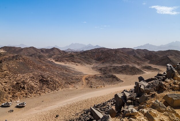 Sabbia marrone, dune del deserto e colline sul cielo blu