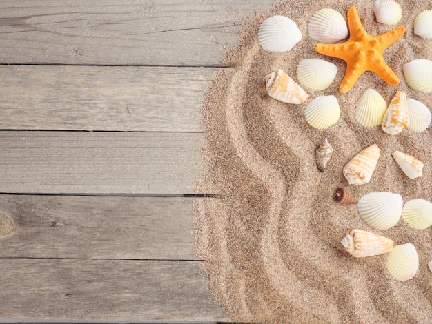 Sabbia su tavole di legno con conchiglie Vacanze estive sfondo estivo