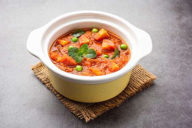 Sabzi di Carrot Curry o Garar Gravy realizzato con passata di pomodoro e spezie, servito in una ciotola