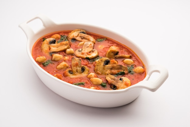 Sabzi di funghi al curry di pomodoro con ceci e spinaci, primo piatto indiano servito con Paratha e riso bianco cotto
