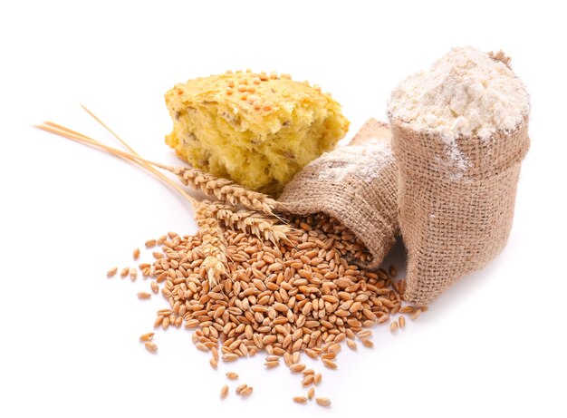 Sacchetti di sacco con chicchi di grano, farina e pane su bianco