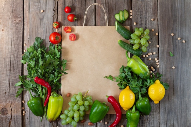 Sacchetto della spesa di carta con frutta e verdura fresca sulla tavola di legno