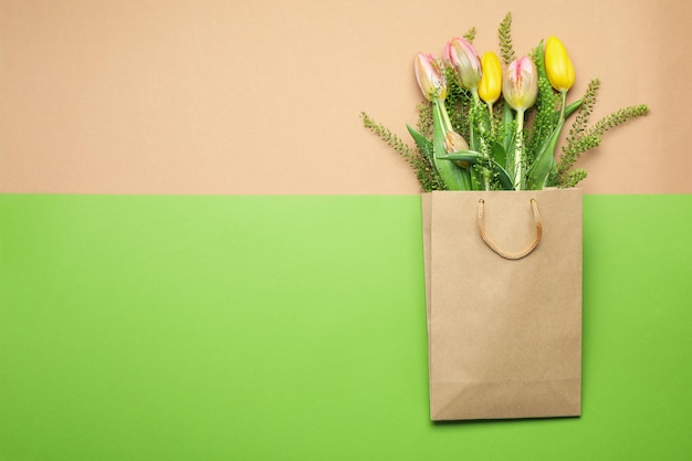 Sacchetto di carta con fiori su fondo bicolore