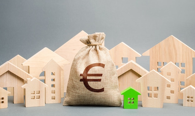 Sacchetto di soldi in euro e una città di figure di casa. Acquisto di immobili, prezzo equo. Bilancio comunale della città.