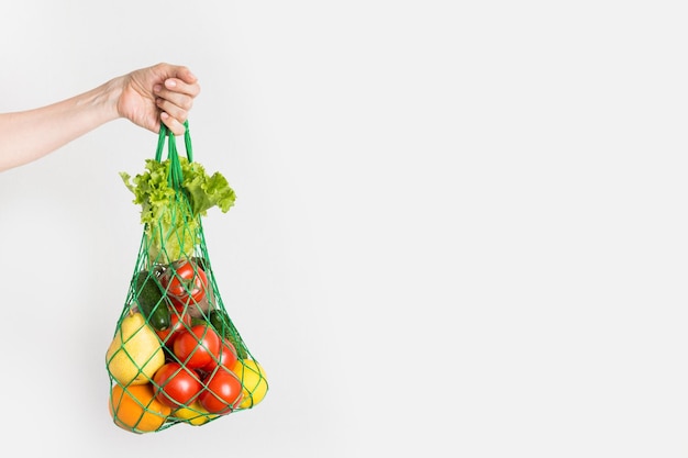 Sacchetto in rete di frutta verdura verdura in mano alla donna Zero sprechi Plastic free