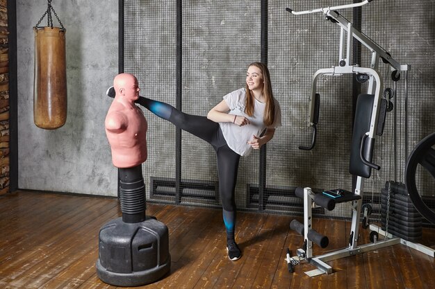 Sacco da boxe bob manichino in palestra giovane donna calci