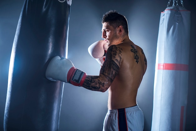 Sacco da boxe uomo sudato in palestra