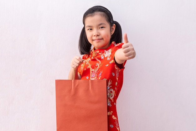 Sacco di carta asiatico della tenuta della tenuta del cheongsam di usura della ragazza. Capodanno cinese.