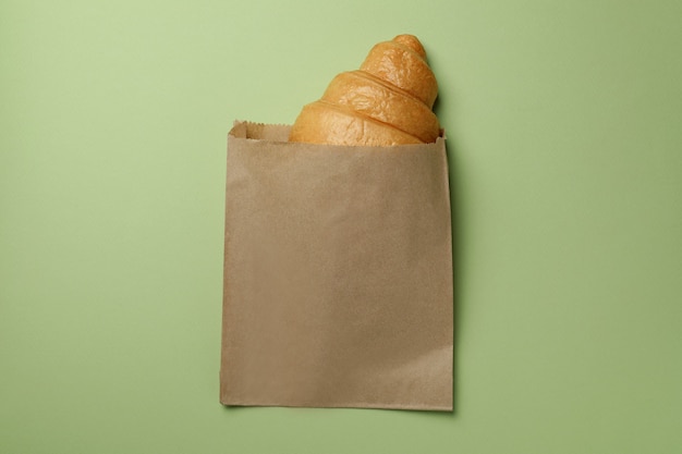 Sacco di carta con croissant sul verde