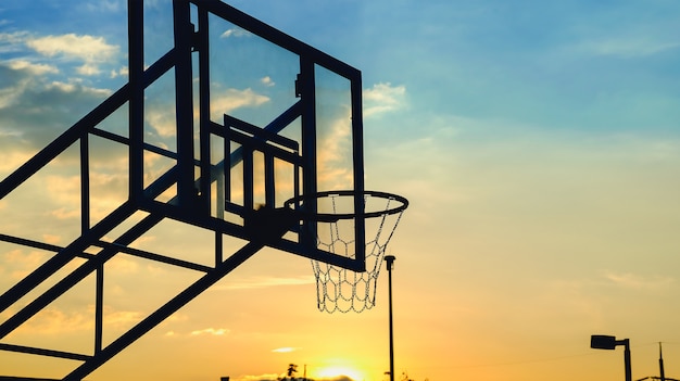 Sagoma del cerchio di pallacanestro. Cerchio di pallacanestro con la priorità bassa della siluetta di tramonto