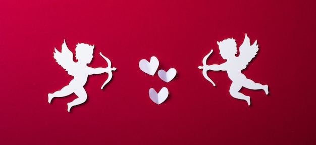 Sagoma di Cupido volante, striscioni di San Valentino felice, stile di arte della carta. Amour su carta rossa
