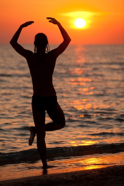 Sagoma di giovane uomo in piedi sulla spiaggia