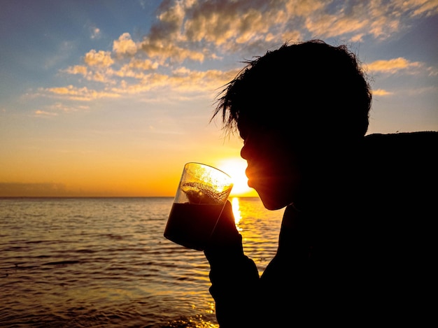 sagoma di persone con alba sulla spiaggia