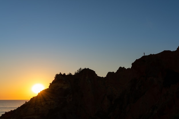 Sagoma di un uomo che scatta una foto all'alba