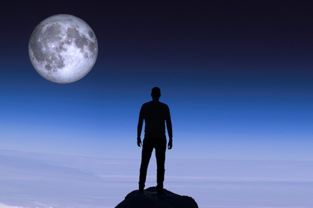 Sagoma di un uomo sullo sfondo della luna