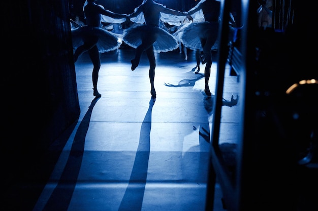 Sagome di ballerine che ballano sul palco sotto i riflettori