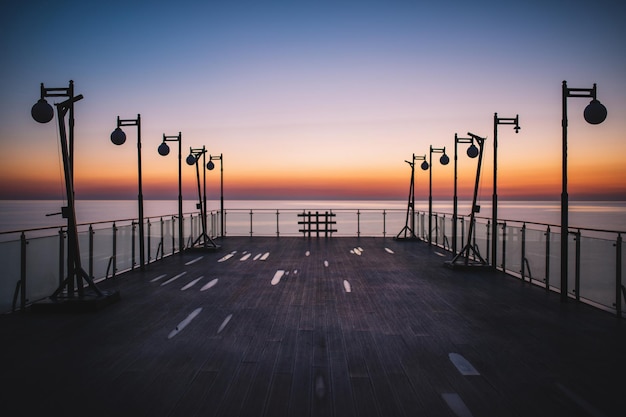 Sagome di lampioni al tramonto in riva al mare