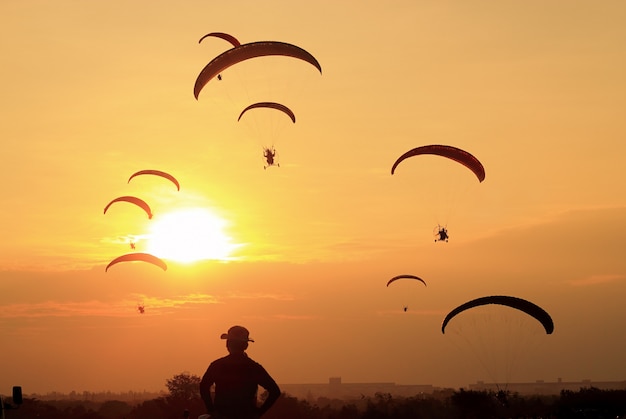 Sagome di paramotore o paracadutista al tramonto