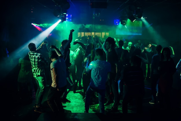 Sagome di persone che ballano in discoteca sulla pista da ballo alla festa