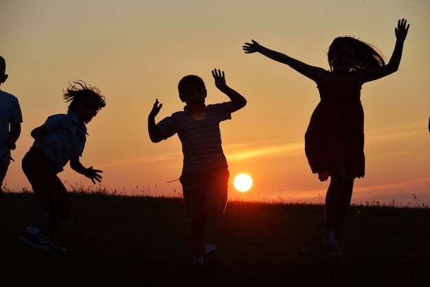 Sagome di persone felici in natura al momento del tramonto