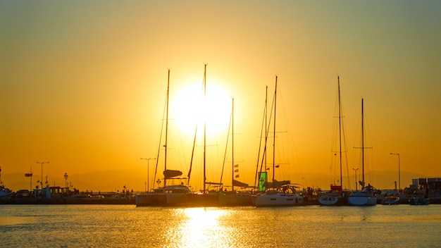 Sagome di yacht e barche al tramonto nel porto di Egina, Isole Saroniche, Greece