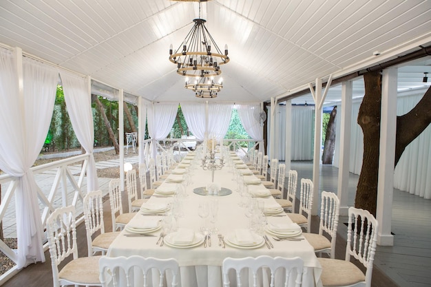 Sala banchetti vuota pronta ad accogliere gli ospiti sulla terrazza estiva. tavola festiva bianca