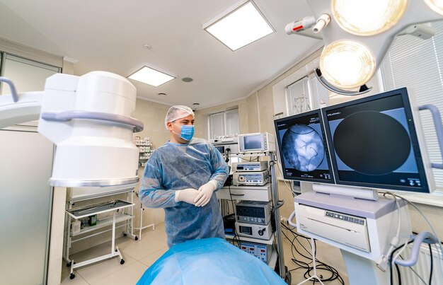 Sala chirurgica in ospedale con apparecchiature di tecnologia robotica, neurochirurgo del braccio della macchina. Chirurgo in camice in sala operatoria.