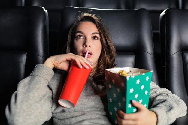 Sala cinema VIP Ritratto di una giovane donna sorpresa alla prima di un film Popcorn e coca cola