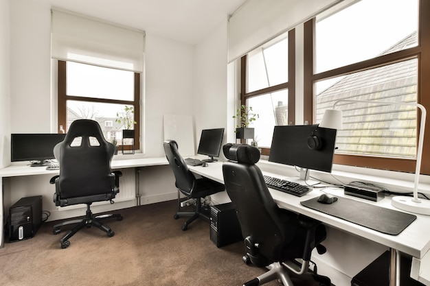 Sala computer con tre postazioni di lavoro ed elettrodomestici moderni in una casa accogliente