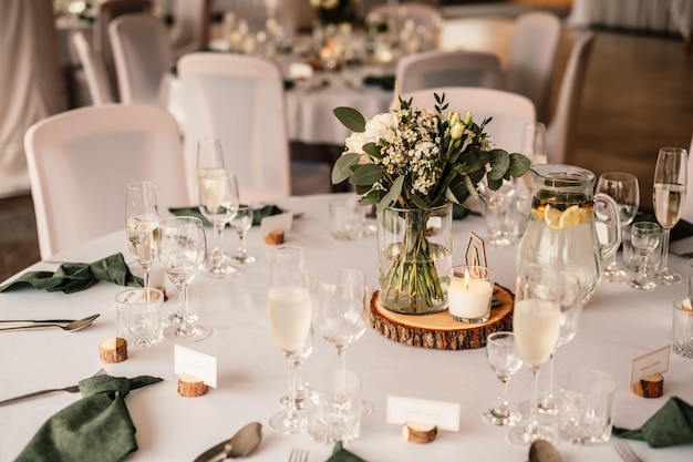 Sala decorata per cerimonia nuziale Banchetto nuziale Le sedie e la tavola rotonda per gli ospiti servite con fiori di posate